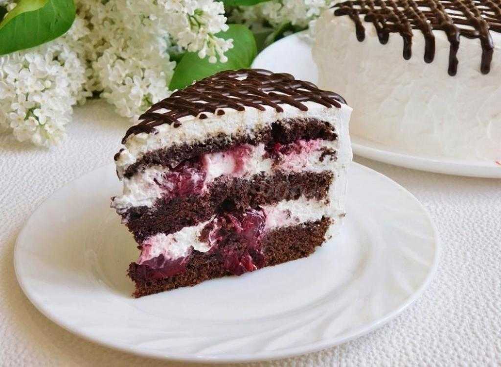 Шоколадный бисквитный торт, украшенный ягодами сверху и в начинке